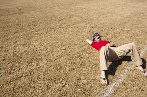 Man taking a nap in a grassy field