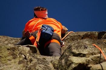 Man dressed in orange rock climbing