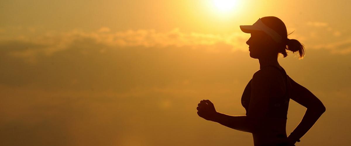 Woman running with the sun in the background