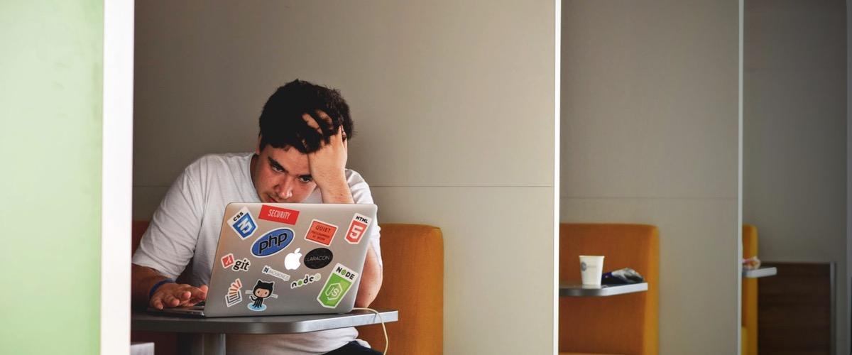 Man in white shirt using a laptop