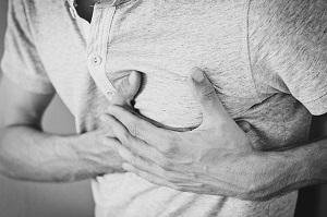 Black and white photo of a man grabbing his chest