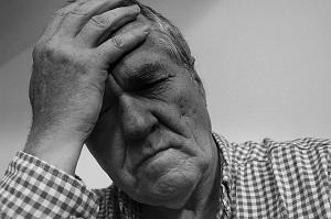 Black and white photo of a man resting his head on his hand