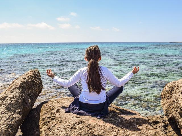 Girl meditating in front of a body of water