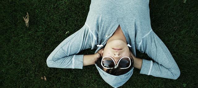 Woman lying in grass, relaxed