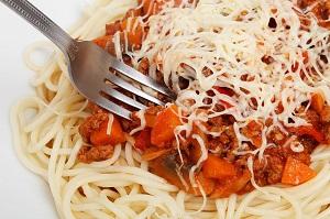 Plate of spaghetti with sauce and cheese on top